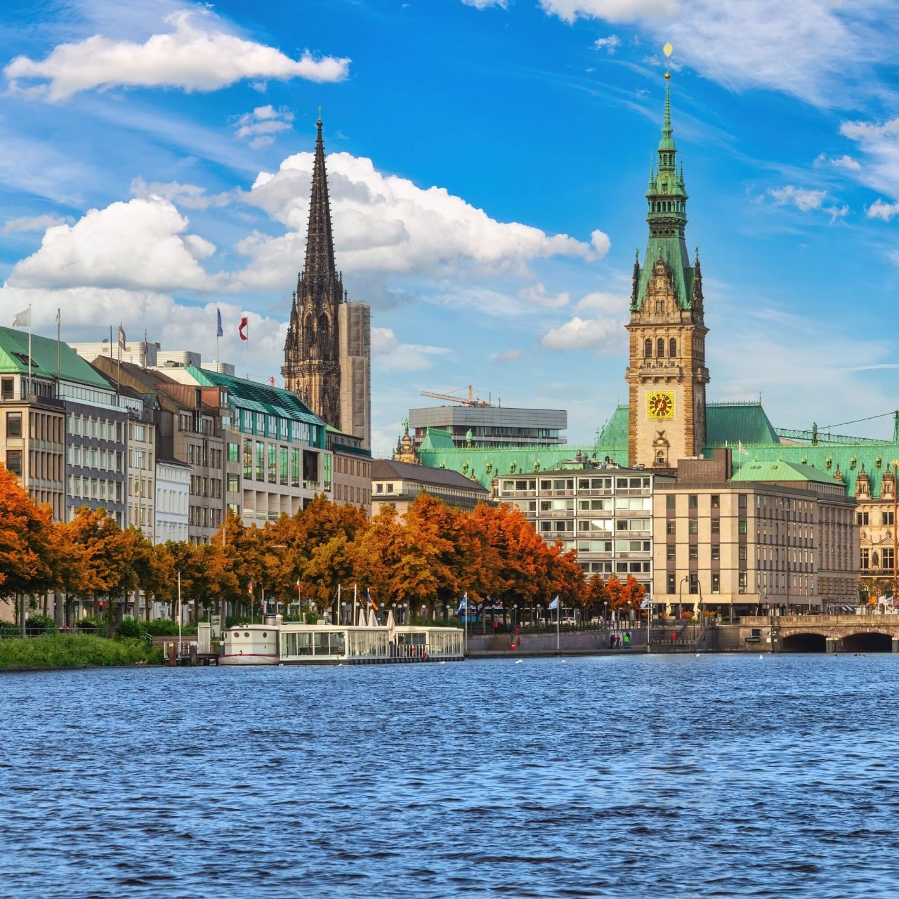 An image of Hamburg's lake, with autumn trees and historic bulidings in the background